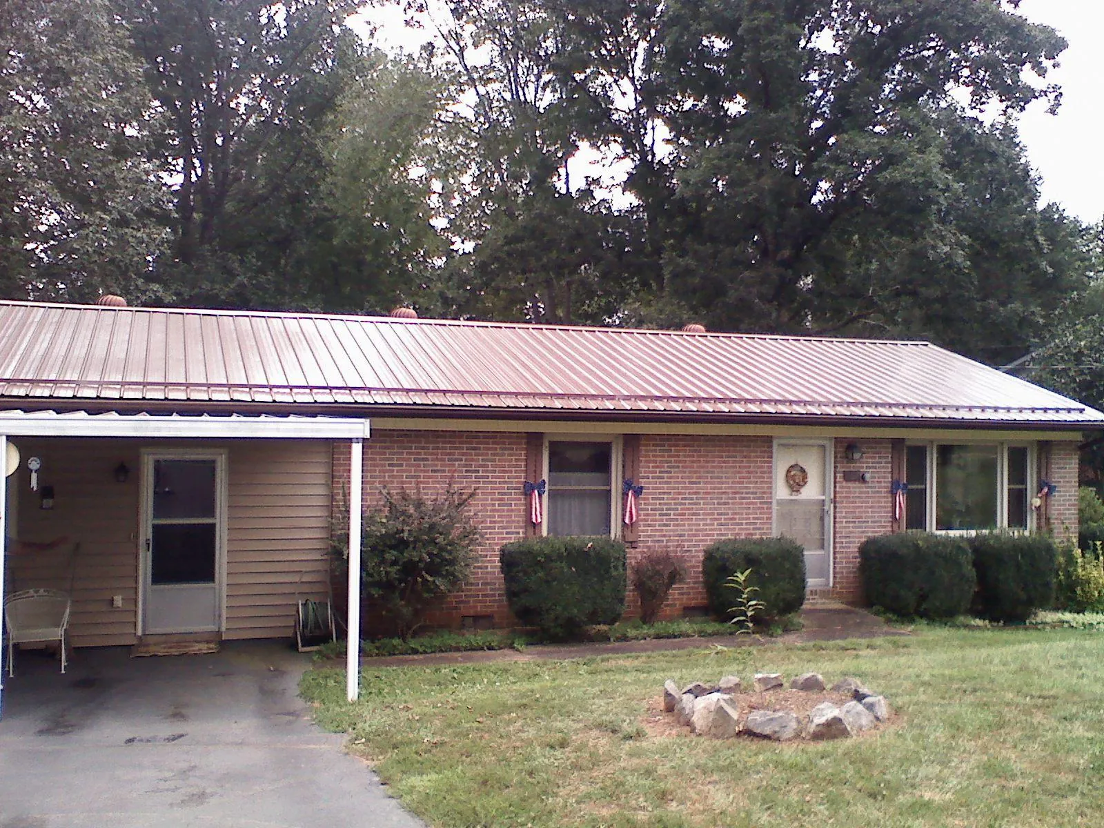 Bronze metal roof and carport on a brick ranch home — Roof Repair work by our crew in Osceola